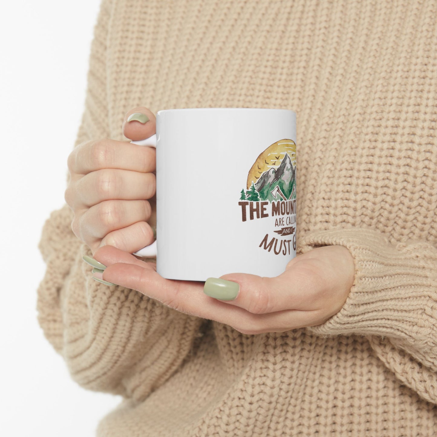 White mug with "The mountains are calling" and trees design.