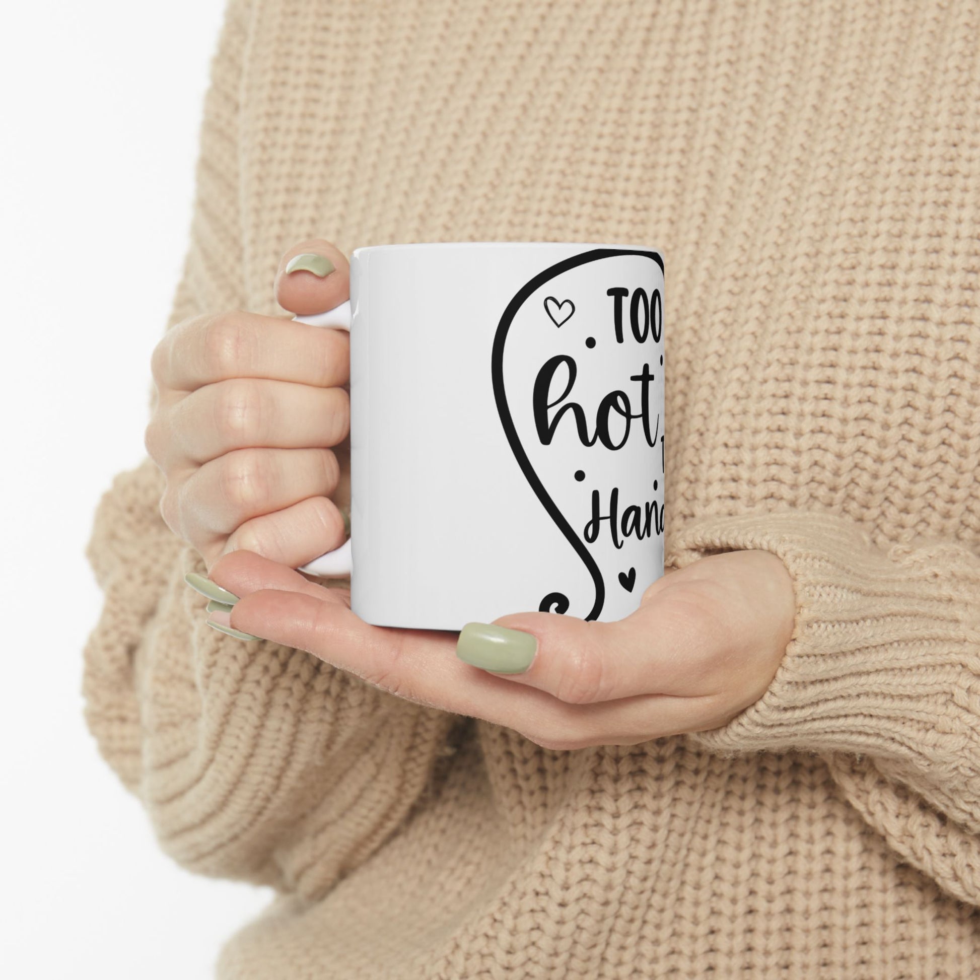 White mug held by hands, with "Too hot to handle" text.