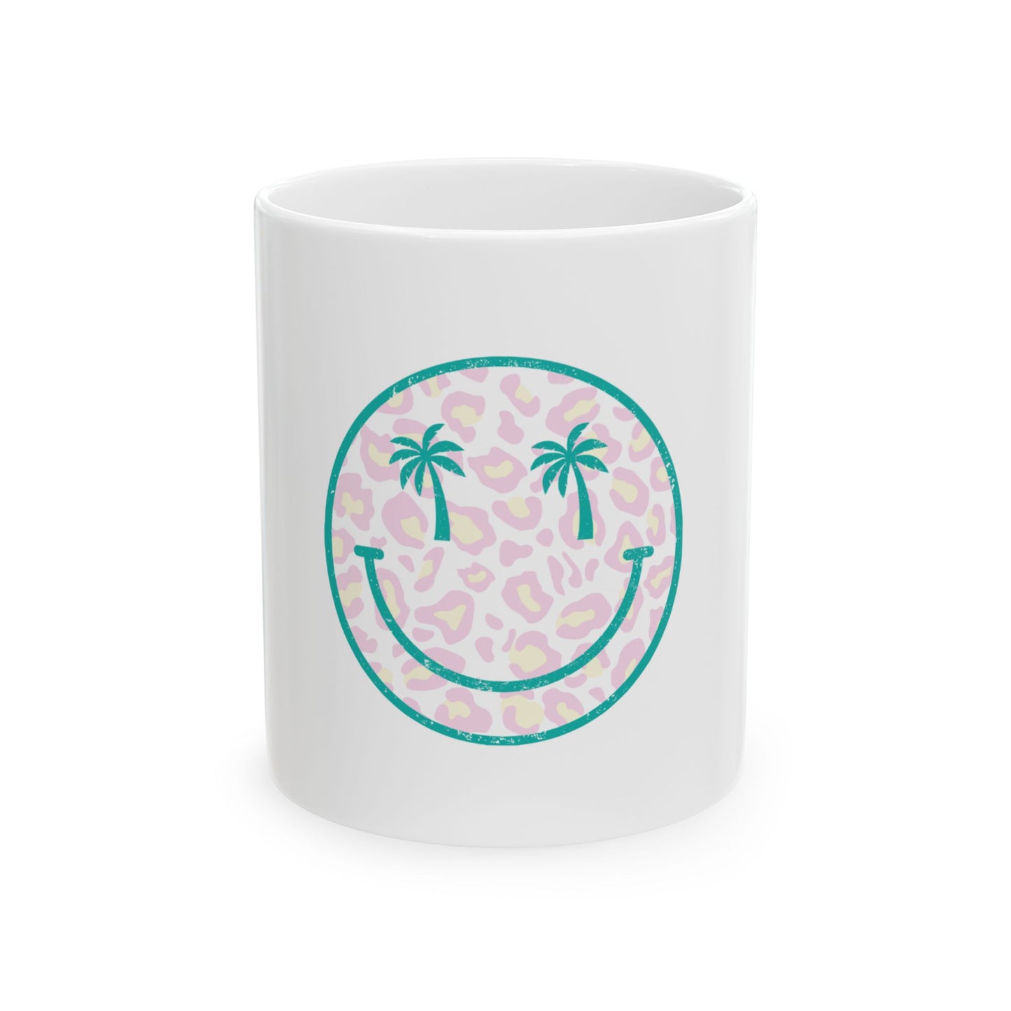 White mug with teal smiley face graphic with palm trees on leopard print.