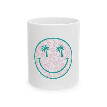 White mug with teal smiley face graphic with palm trees on leopard print.