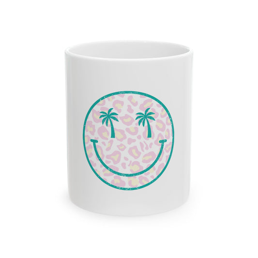White mug with teal smiley face graphic with palm trees on leopard print.