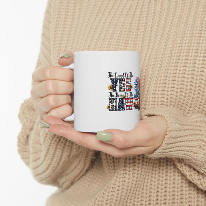 White mug with "Land of the Free, Home of the Brave" text and patriotic icons.