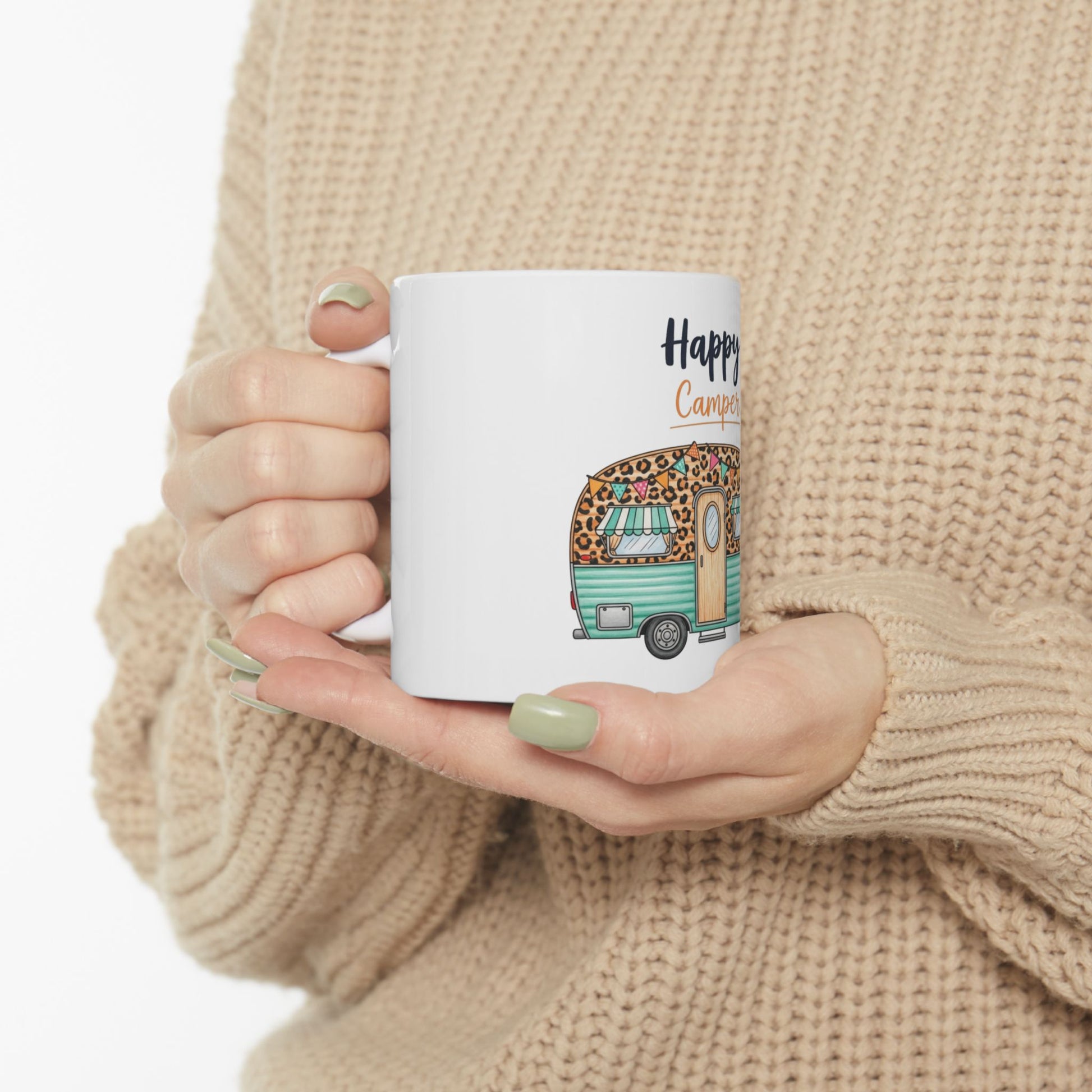 White mug with "Happy Camper" text and a leopard-print caravan illustration.