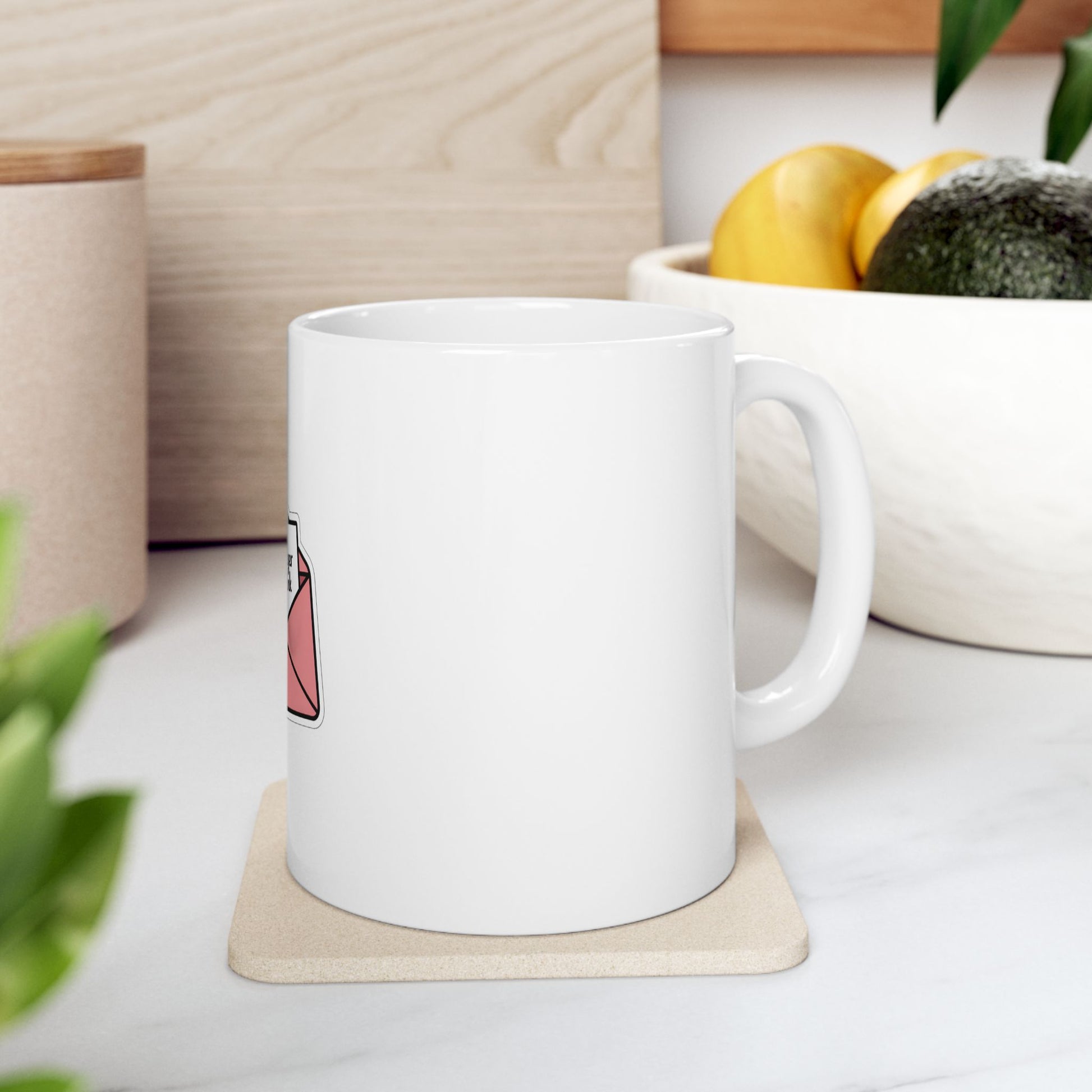 White mug with a pink envelope design on a white coaster.
