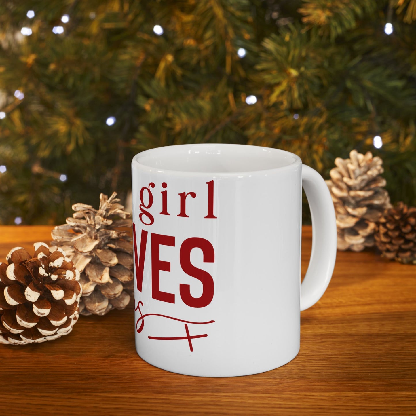 White mug with "girl" and "loves" in red text, on a wooden table.