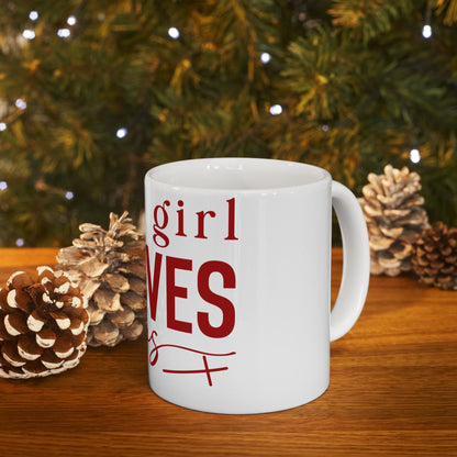 White mug with "girl" and "loves" in red text, on a wooden table.