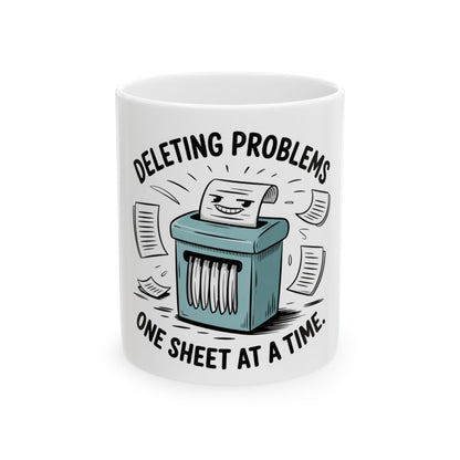 Mug with cartoon paper shredder deleting problems one sheet at a time.