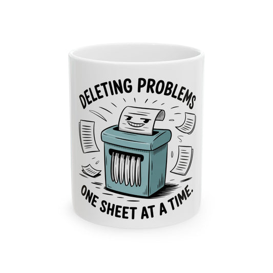 Mug with cartoon paper shredder deleting problems one sheet at a time.