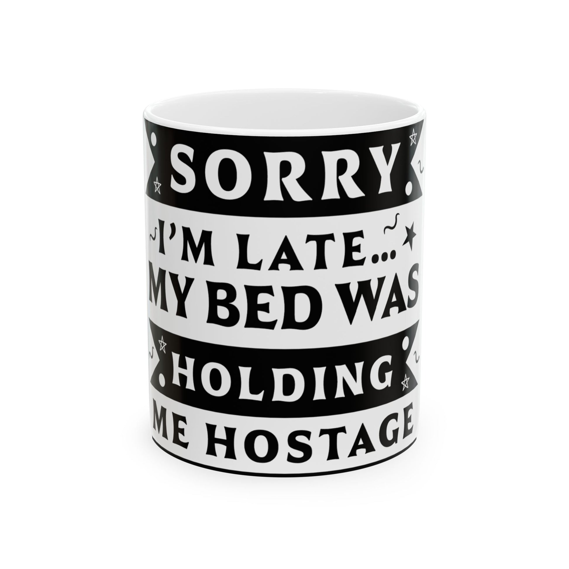 White mug with black text: "SORRY I'M LATE... MY BED WAS HOLDING ME HOSTAGE."