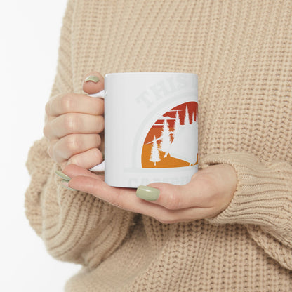 White mug with "THIS IS CAMPING" text and a sunset scene.