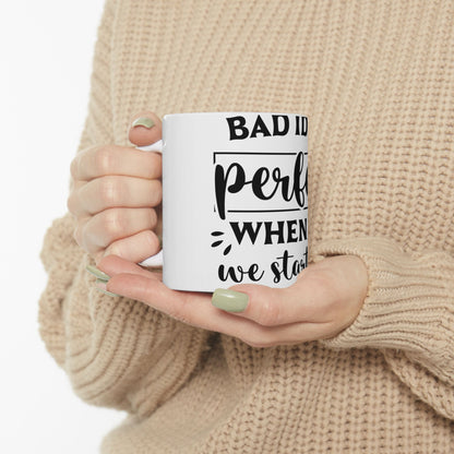 White mug with black text "BAD ID per when we start".