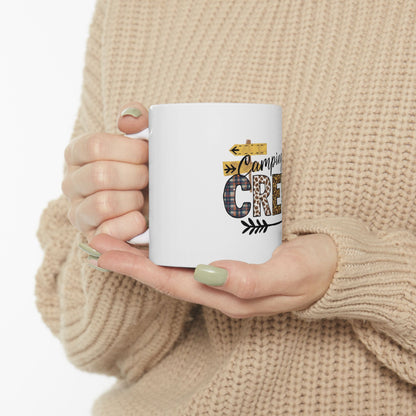 White mug with "Camping Crew" design held by hands.