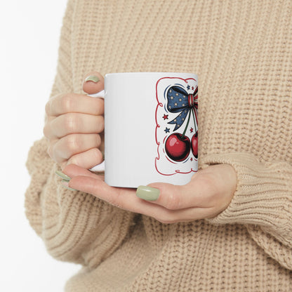 White mug with red cherries and a blue bow design.