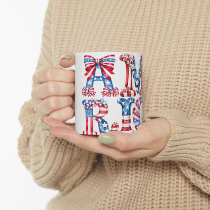 White mug with "AMERICA" in patriotic letters, held by person.