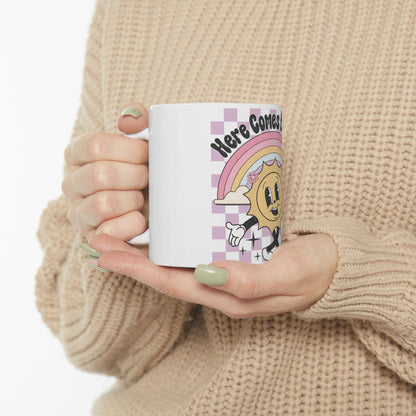 White mug with cartoon sun, rainbow, and "Here Comes" text.