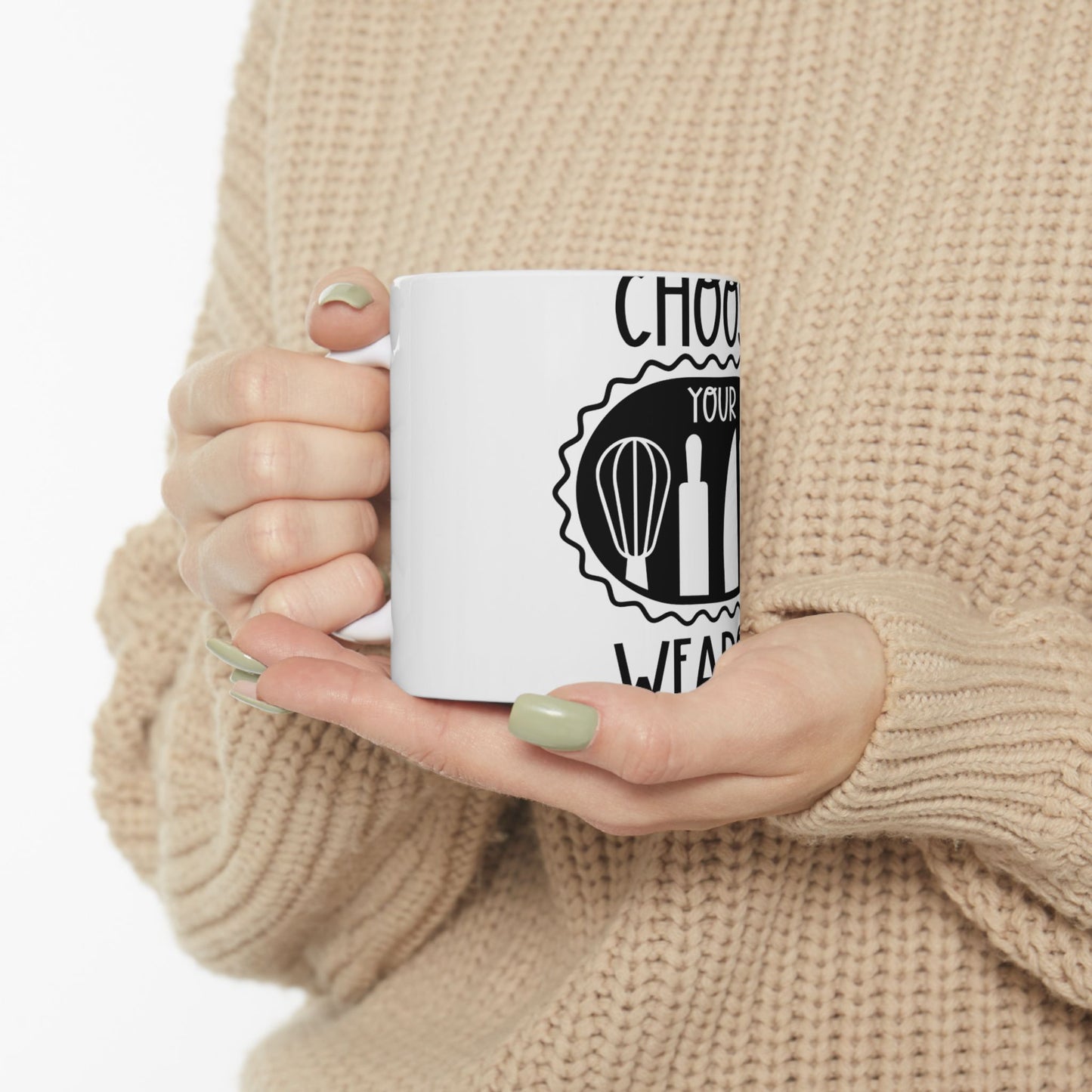 White mug with "Choose Your Weapon" text and baking tools.