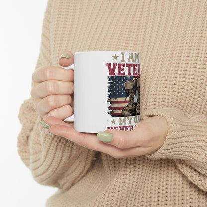 White mug with "I Am A Veteran" text, combat boots, and American flag.