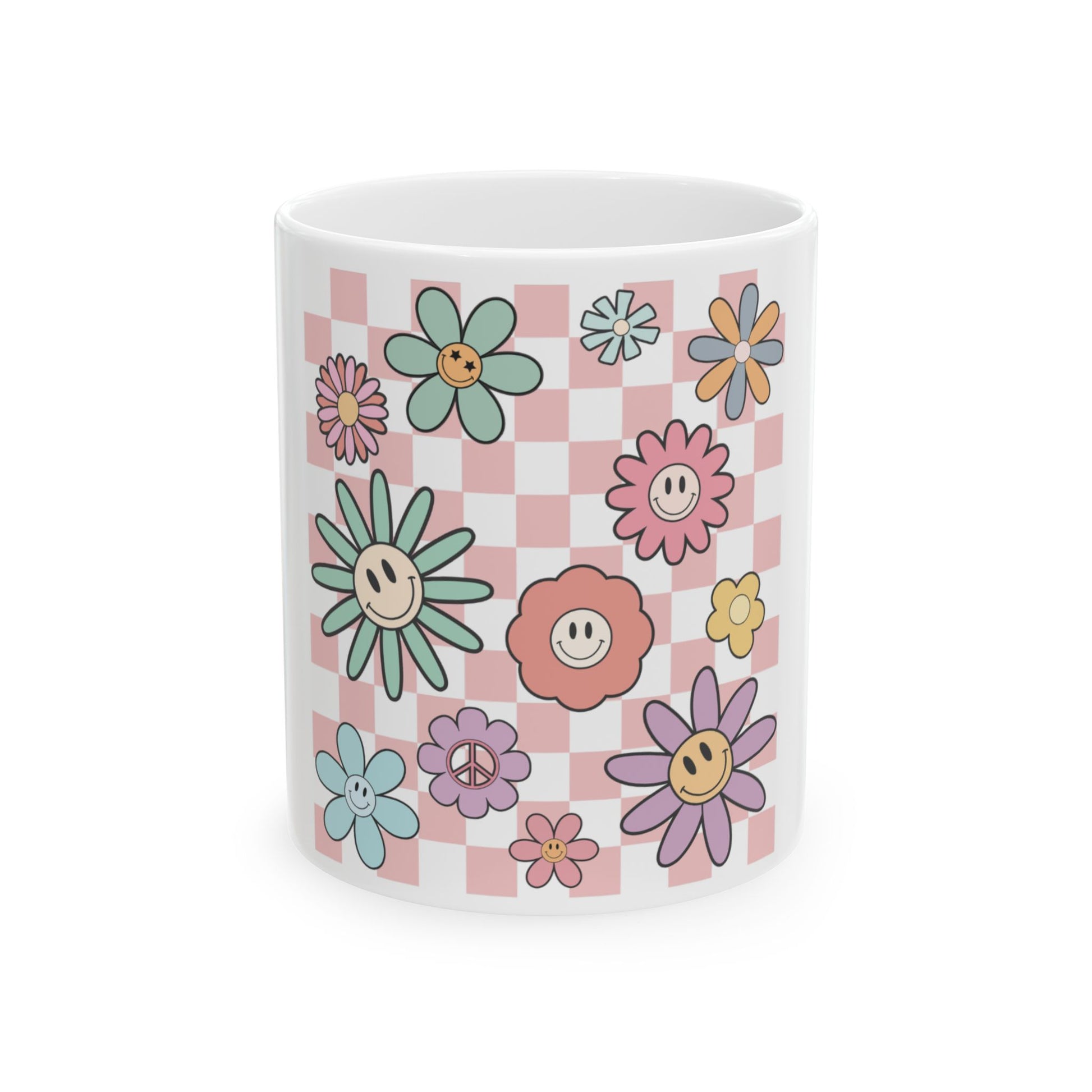 White mug with pastel flowers and peace signs on a pink checkered background.