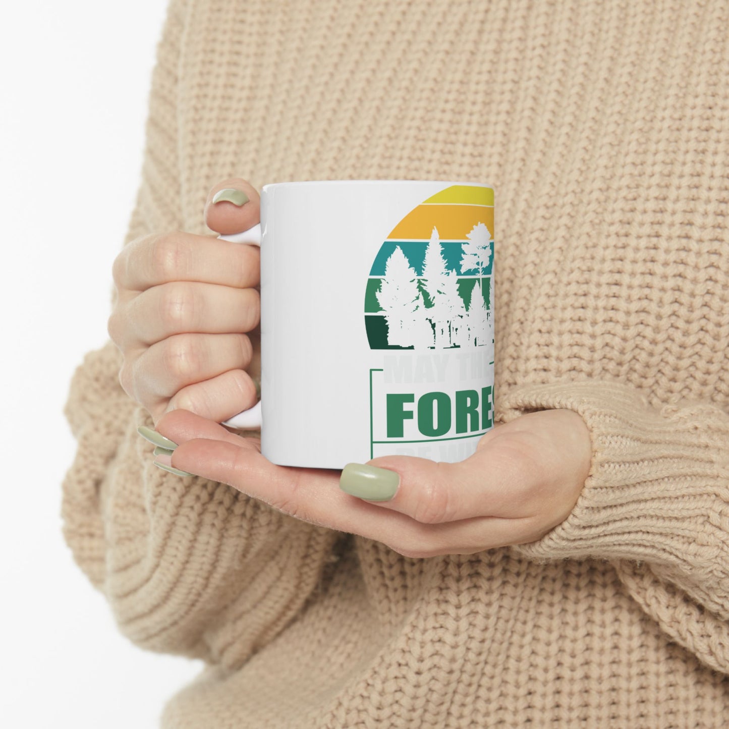 White mug with green forest sunset graphic and text.