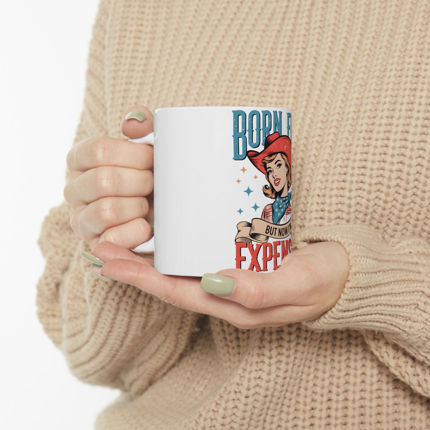 White mug with "Born Free But Now Expensive" text and retro woman graphic.