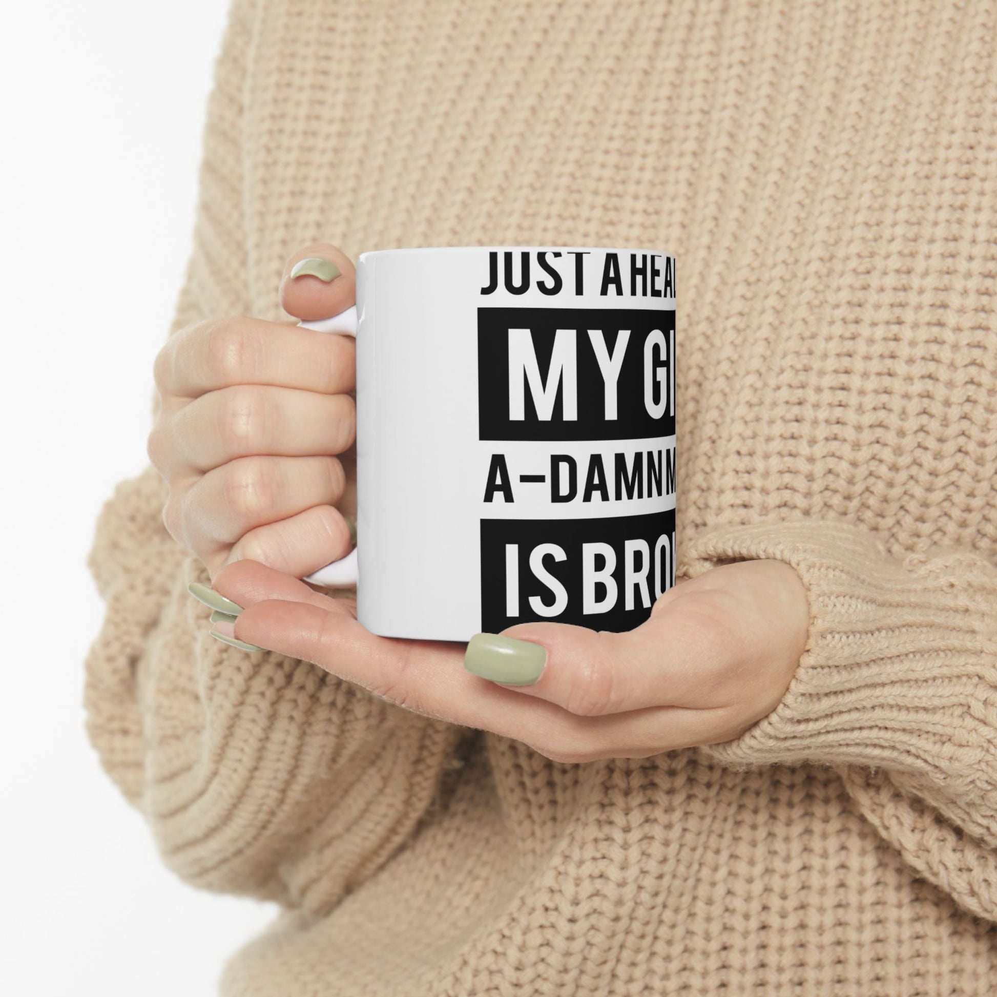 White mug with "JUST A HEA MY G A-DAMN IS BRO" text held by hands.
